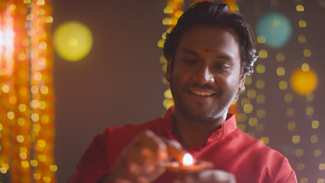Hombre-Celebrando-El-Festival-De-Diwali-Sosteniendo-Una-Lámpara-De-Aceite-Diya-Encendida-Hacia-La-Cámara